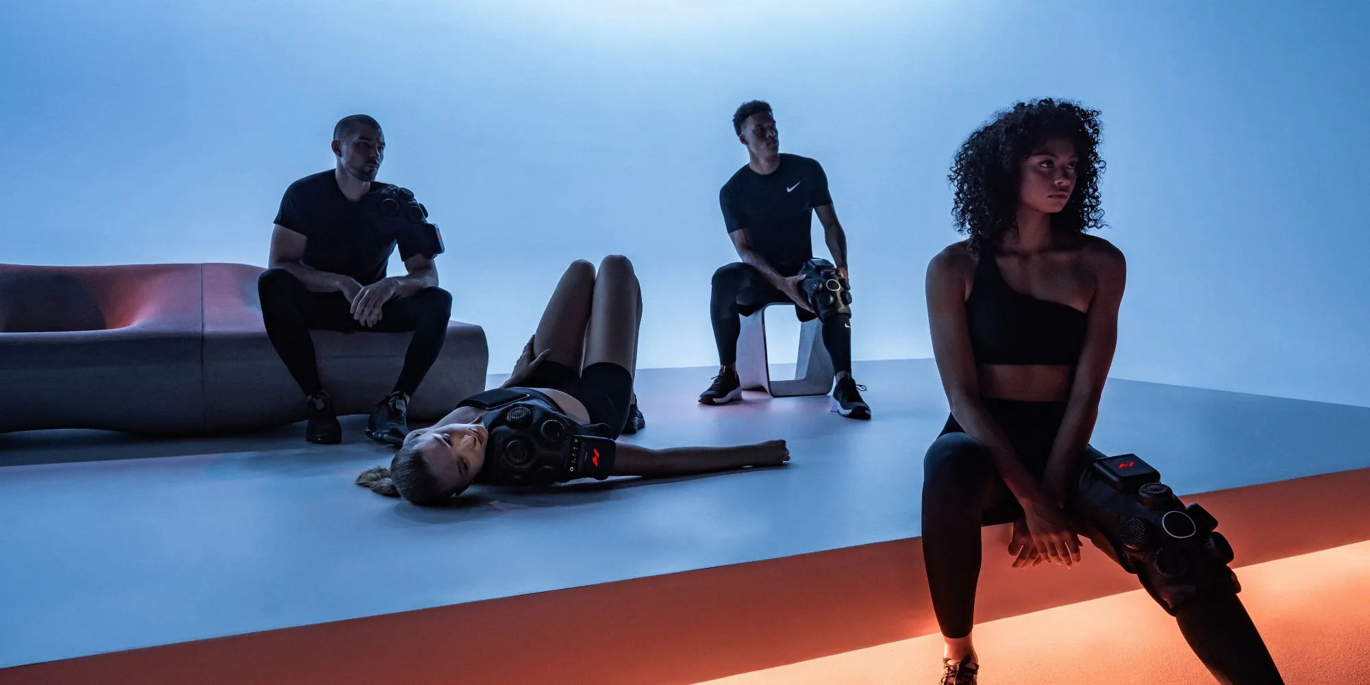 Gruppe von Personen nutzt Hyperice Regenerationsgeräte am Knie