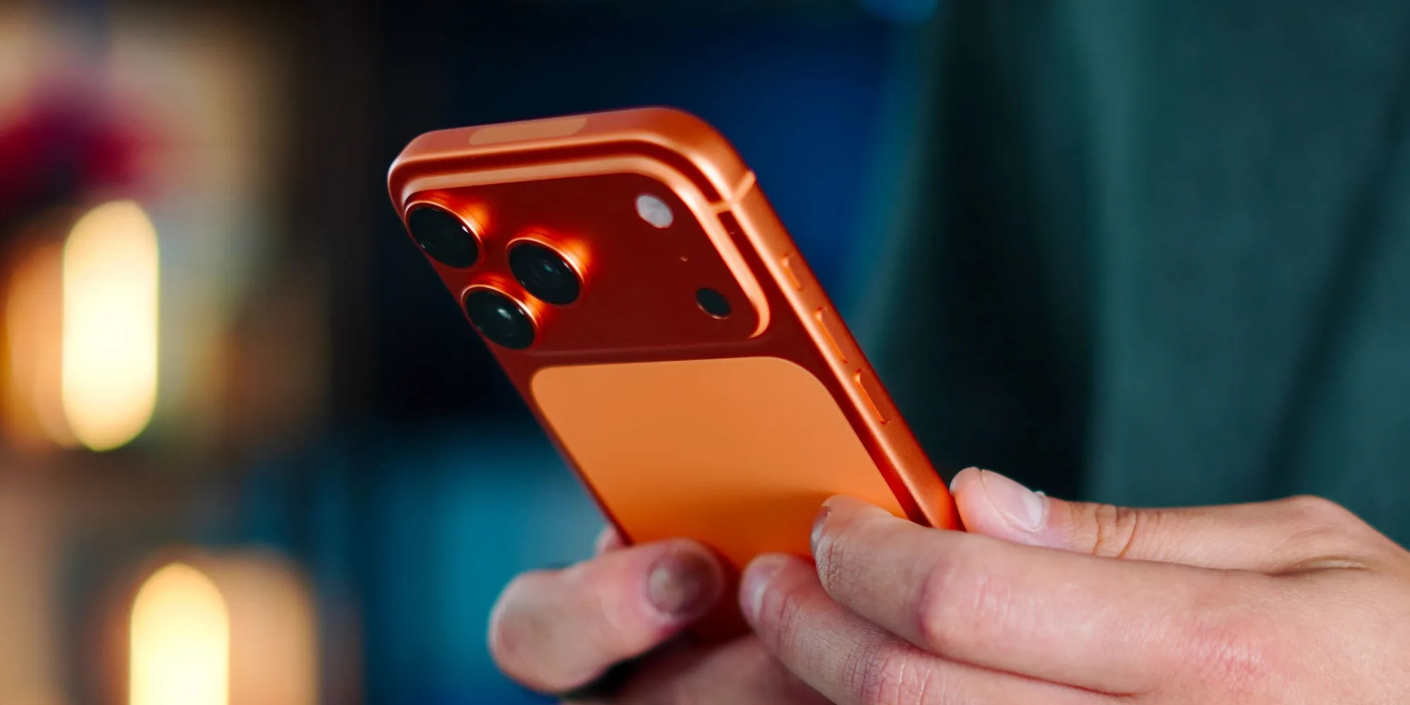 Ein Nutzer hält das iPhone 17 Pro in Cosmic Orange in der Hand